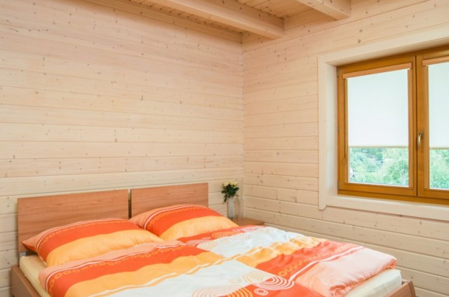 Ložnice v přízemí srubového domu