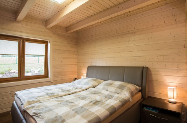 Ložnice v přízemí srubového domu